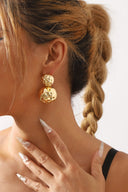 Glimmering Layered Hammered Round Earrings in Gold on neutral background
