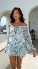 Cyrene Floral Off-Shoulder Mini Dress in Shoulder Mini Dress - Floral Green close-up of floral print hemline and